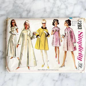 May include: A vintage Simplicity sewing pattern, number 7283, showcasing illustrations of women's coats and dresses. The pattern includes designs in white, yellow, and pink. It is for a size 12 with a 81 cm bust.