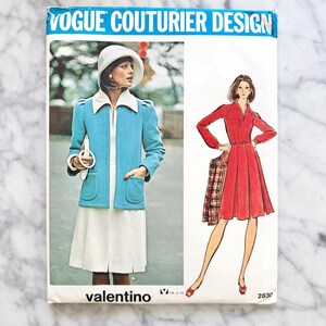 May include: Vintage Vogue Couturier Design sewing pattern featuring a Valentino design. The pattern cover shows a woman in a light blue jacket and white dress, and another in a red dress. The pattern number is 2830.