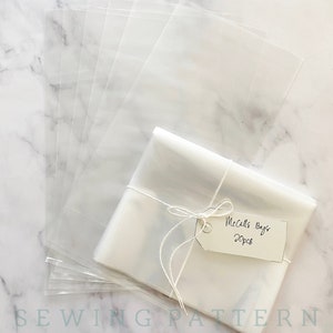 May include: A stack of clear plastic bags with a tag that reads "McCall's Bags 20pcs" tied with twine.