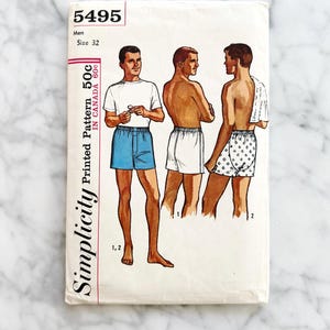 May include: Vintage Simplicity printed pattern for men's shorts, size 32. The pattern features illustrations of men in various shorts styles, including blue, white, and patterned options. The pattern is marked 50c in Canada.