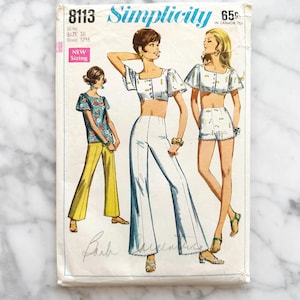 May include: Vintage Simplicity sewing pattern number 8113 for a women's top and pants set. The pattern includes instructions for a cropped top with a button-up front and bell-bottom pants. The pattern is for size 10 and has a bust measurement of 32 1/4 inches.