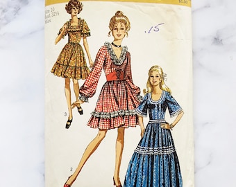 May include: Vintage Simplicity sewing pattern number 8875 for a dress. The pattern includes three different styles of dresses, all with a ruffled hem. The dress on the left is a short, floral print dress. The dress in the center is a red and white gingham dress with long sleeves. The dress on the right is a long, blue and white gingham dress.