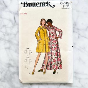 May include: Vintage Butterick sewing pattern, size 16, featuring illustrations of two coats. One coat is yellow with a Peter Pan collar, and the other is a floral print. The pattern number is 5743.