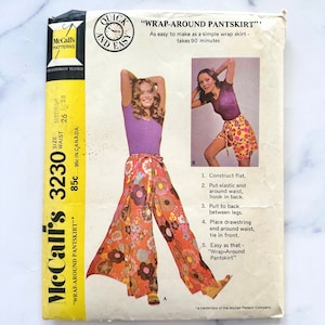 May include: McCall's sewing pattern number 3230 for a "Wrap-Around Pantskirt" in sizes Medium (waist 26-28 inches). The pattern is quick and easy to make and takes 90 minutes to complete. The pattern shows a woman wearing a floral print pantskirt with a purple top.