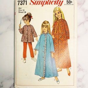 Puede incluir: Un patrón de costura vintage Simplicity para ropa de niña. El patrón es para una bata azul, una bata roja y una chaqueta roja con pantalones a juego. El número del patrón es 7371 y el precio es de 50 centavos.