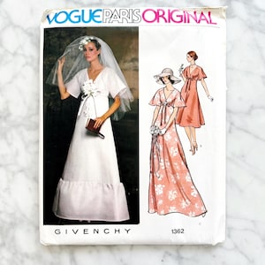 May include: A white ceramic mug with a black handle and the text "But First, Coffee" in a black, bold font. The mug is on a white surface.