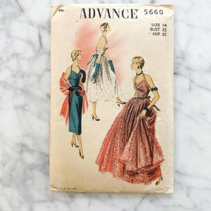 May include: Vintage Advance sewing pattern 5660 with illustrations of three elegant dresses. The cover is aged with the text "ADVANCE" at the top, along with size and measurement details. The background is a marble pattern.