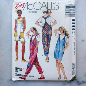 May include: A McCall's sewing pattern envelope for style 6393, size Y. The front features illustrations of four different overall and jumper designs, including short and long versions with various patterns. Text includes 'Easy McCall's', '6393', and 'Learn to sew for fun'.