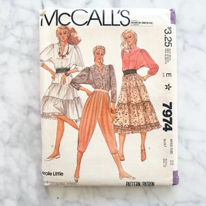 Könnte beinhalten: Ein Vintage-Schnittmuster von McCall's mit Illustrationen von drei verschiedenen Outfits. Das Schnittmustercover zeigt den Text "McCall's" und "7974". Die Outfits umfassen einen Stufenrock, ein Blusen- und Hosen-Set und ein Kleid.
