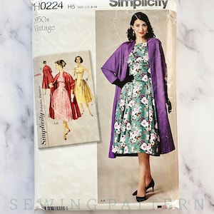 May include: Vintage Simplicity sewing pattern for a dress and jacket. The pattern is for sizes 6-14 and is from the 1950s. The dress has a floral print and the jacket is purple.