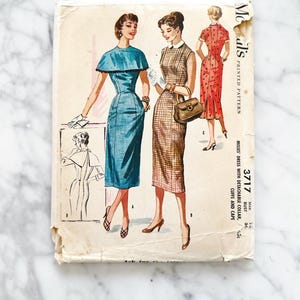 May include: Vintage sewing pattern for a dress with a detachable collar, cuffs, and cape. The pattern is for sizes 34 and 36 bust. The pattern is printed on a white background with illustrations of the dress in blue, red, and brown.