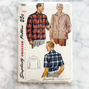 May include: Vintage Simplicity printed pattern 1961. The cover features illustrations of men's shirts and jackets in various styles. The pattern is marked "Large" and priced at 25 cents. The cover is aged with wear.