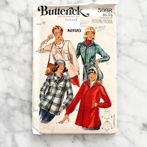 May include: A vintage sewing pattern for a shirt and jacket by Butterick, featuring a Kenzo design. The pattern is for size 10 and includes instructions for making a plaid shirt, a belted jacket, and a red jacket. The pattern number is 5098.