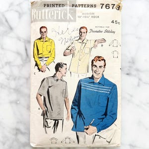 May include: Vintage Butterick printed pattern 7673 for men's shirts. The pattern features illustrations of various shirt styles, including a yellow button-down, a striped shirt, a gray polo, and a blue shirt with decorative stitching. The pattern is for a medium 15"-15.5" neck size.