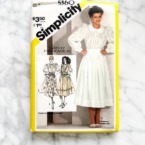 May include: Vintage Simplicity sewing pattern number 5360 for a white blouse and skirt. The pattern includes instructions for a purchased eyelet collar. The pattern is by Cathy Hardwick.
