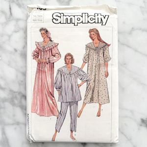 Puede incluir: Patrón de costura Simplicity para un camisón o pijama. El patrón muestra tres estilos diferentes: un camisón largo de color rosa con ribete de encaje, un camisón largo de estampado floral con ribete de encaje y un pijama a rayas con una parte superior de manga larga y pantalones.