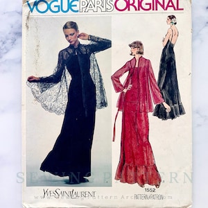 May include: Vintage Vogue Paris Original sewing pattern for a dress with a cape. The pattern is by Yves Saint Laurent and has the number 1552 on it.