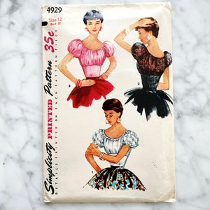 Puede incluir: Patrón de costura vintage Simplicity número 4929 para una blusa de mujer con mangas abullonadas. El patrón incluye tres estilos diferentes de blusas, cada una con un escote y una longitud de manga diferentes. El patrón está impreso en papel blanco con texto negro e ilustraciones. El patrón es para la talla 12, busto 30, y cuesta 35 céntimos.