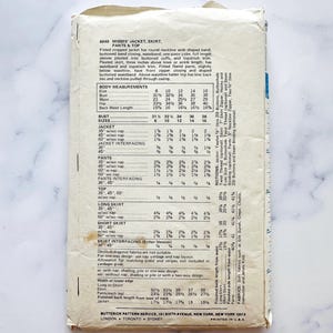 Pu&ograve; includere: Un cartamodello vintage per una giacca corta, una gonna, dei pantaloni e un top. Il cartamodello &egrave; per taglie da donna 8-16 e include le istruzioni per la realizzazione di ogni capo. Il cartamodello &egrave; stampato su uno sfondo bianco con testo nero.