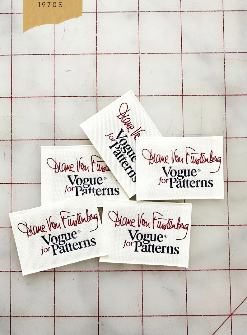 K&ouml;nnte beinhalten: Vier wei&szlig;e Stoff-Etiketten mit roter Schrift, die "Diane Von Furstenberg" lautet, und schwarzem Text, der "Vogue&reg; for Patterns" lautet.