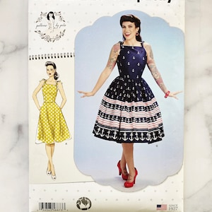 May include: Simplicity sewing pattern S8873 D5 for a dress with two variations. The dress has a fitted bodice and a full skirt. One variation features a yellow polka dot print and the other features a blue and white striped print with anchors. The pattern is for sizes US 4-12, TALLA EURO 30-36, TAILLE FR 32-40.