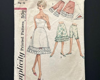 May include: Vintage Simplicity sewing pattern number 4729 for a slip with a lace trim. The pattern includes three different styles: a full slip, a shorter slip, and a pair of bloomers. The pattern is printed on white paper with black text and illustrations.