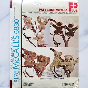 May include: A vintage McCall's sewing pattern for a set of stuffed animals. The pattern is number 5830 and costs £1.75. The pattern includes instructions for easy velcro fasteners. The pattern shows a variety of stuffed animals, including a koala, a monkey, and a lemur.