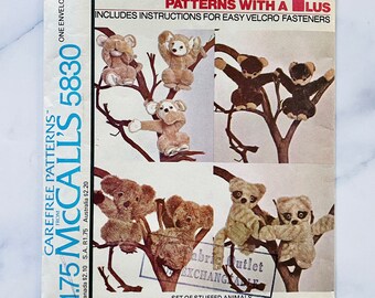 Könnte beinhalten: Ein Vintage-Nähmuster von McCall's für einen Satz Stofftiere. Das Muster ist die Nummer 5830 und kostet 1,75 $. Das Muster enthält Anweisungen für einfache Klettverschlüsse. Das Muster zeigt eine Vielzahl von Stofftieren, darunter ein Koala, ein Affe und ein Lemur.