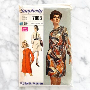 Puede incluir: Patrón de costura vintage Simplicity número 7803 para un vestido. El patrón incluye instrucciones para dos estilos de vestidos diferentes, uno con una tela naranja sólida y el otro con un estampado abstracto colorido. El patrón es para una talla 16 con una talla de busto de 96,5 cm.