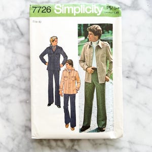 May include: A vintage Simplicity sewing pattern, size 40, with illustrations of men's suits. The pattern packet is white with green and black text. The suits are in shades of blue, tan, and green.