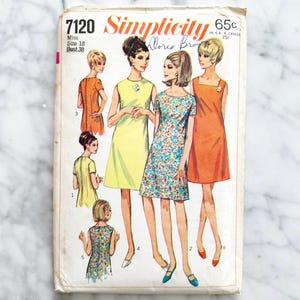 May include: Vintage Simplicity sewing pattern 7120 featuring illustrations of women in dresses. The pattern cover shows a yellow, floral, and orange dress design. The text on the cover reads "Simplicity" and "Doris Brow".