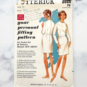 May include: Vintage sewing pattern for a dress, featuring a white dress with long sleeves and a crew neckline. The pattern is for sizes 8-10-12-14-16-18 and is marked "New Sizing".