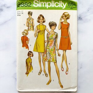 May include: Vintage Simplicity sewing pattern number 8882 for a dress. The pattern is for size 12, bust 34, and is for misses. The pattern shows four different styles of dresses, all with short sleeves and a scoop neck. The dresses are in various colors, including yellow, orange, and floral print.