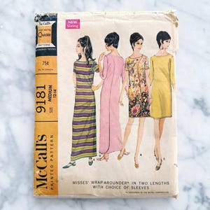 May include: Vintage McCall's sewing pattern envelope for a wrap-around dress in two lengths with a choice of sleeves. The pattern number is 9181 and the size is medium. The envelope features a line drawing of four women wearing the dress in different styles.