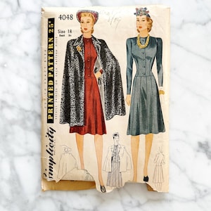 May include: Vintage Simplicity sewing pattern number 4048 for a dress and cape. The pattern is for size 18 with a bust measurement of 30 inches. The pattern features a woman wearing a red dress with a black cape and a woman wearing a blue dress with a matching cape.