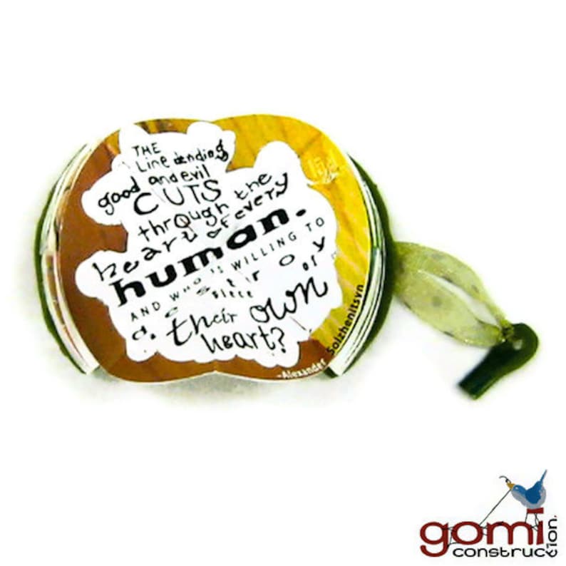 May include: A yellow and white paper scroll with a quote about the human heart. The quote reads "The line dividing good and evil cuts through the heart of every human. And who is willing to slice off a piece of their own heart?" - Alexander Solzhenitsyn