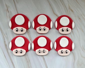 May include: Six red and white mushroom-shaped decorations with black eyes.