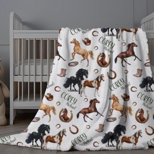 Pu&ograve; includere: Coperta in pile bianca con un motivo ripetuto di cavalli di vari colori, stivali da cowboy, ferri di cavallo e cappelli. Il nome "Corey Michael" &egrave; stampato su tutto il design. La coperta &egrave; drappeggiata su una culla bianca.