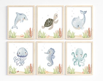 May include: Set of six watercolor illustrations featuring various sea creatures, including a dolphin, turtle, whale, jellyfish, seahorse, and octopus. Each illustration is framed in a light wood frame and features a light blue background with bubbles and seaweed.