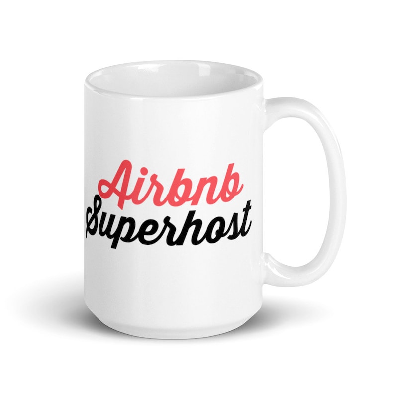 May include: White ceramic mug with the text "Airbnb Superhost" in black and red lettering.
