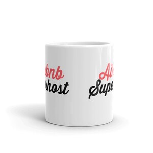 May include: White ceramic mug with the text "Airbnb Superhost" in black and red on the left side and "Air Super" in black and red on the right side.
