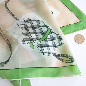 May include: A white silk scarf with a green border and a black and white plaid design of a horse with a green bridle.