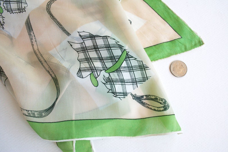 May include: A white silk scarf with a green border and a black and white plaid design of a horse with a green bridle.
