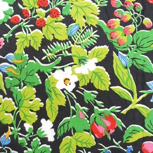 May include: A black fabric with a repeating pattern of green leaves, white flowers, red berries, and blue flowers.