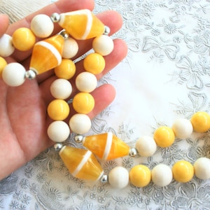 Vintage mod beaded necklace. Retro chunky plastic bead necklace, sunny yellow, white, silver tone,  semi translucent swirl plastic, opaque