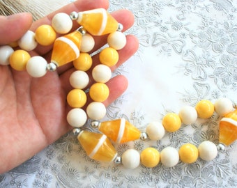 Vintage mod beaded necklace. Retro chunky plastic bead necklace, sunny yellow, white, silver tone,  semi translucent swirl plastic, opaque