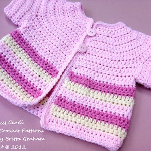 May include: A pink crocheted baby cardigan with white and pink stripes. The cardigan has a button closure and short sleeves. Easy Peasy Cardi Bubnut Crochet Patterns Design by Britta Graham Copyright @ 2012