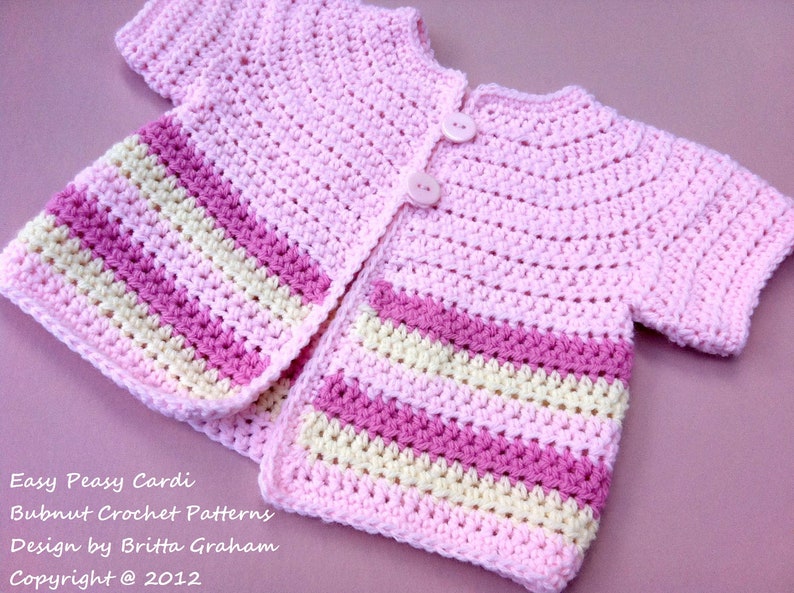 May include: A pink crocheted baby cardigan with white and pink stripes. The cardigan has a button closure and short sleeves. Easy Peasy Cardi Bubnut Crochet Patterns Design by Britta Graham Copyright @ 2012