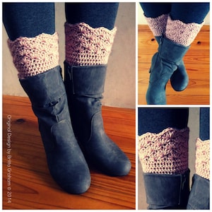 May include: A pair of grey boots with pink crocheted leg warmers. The leg warmers have a scalloped edge and a textured design.