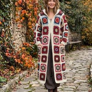 May include: A long-length, hooded crochet cardigan constructed from multicoloured granny squares in shades of red, navy blue, cream, and light blue, featuring long sleeves, two front patch pockets, and a cream-coloured border trim.